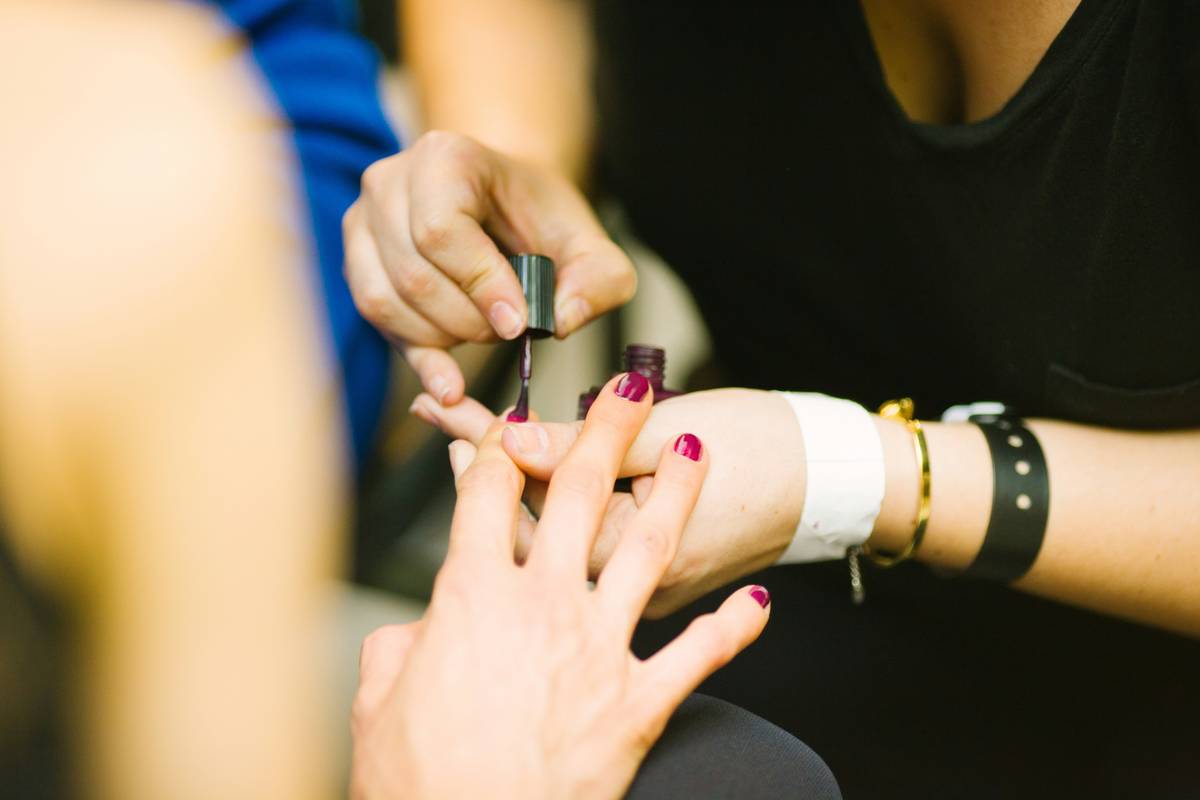 Applying nail foundation product with thin, even strokes for maximum adhesion